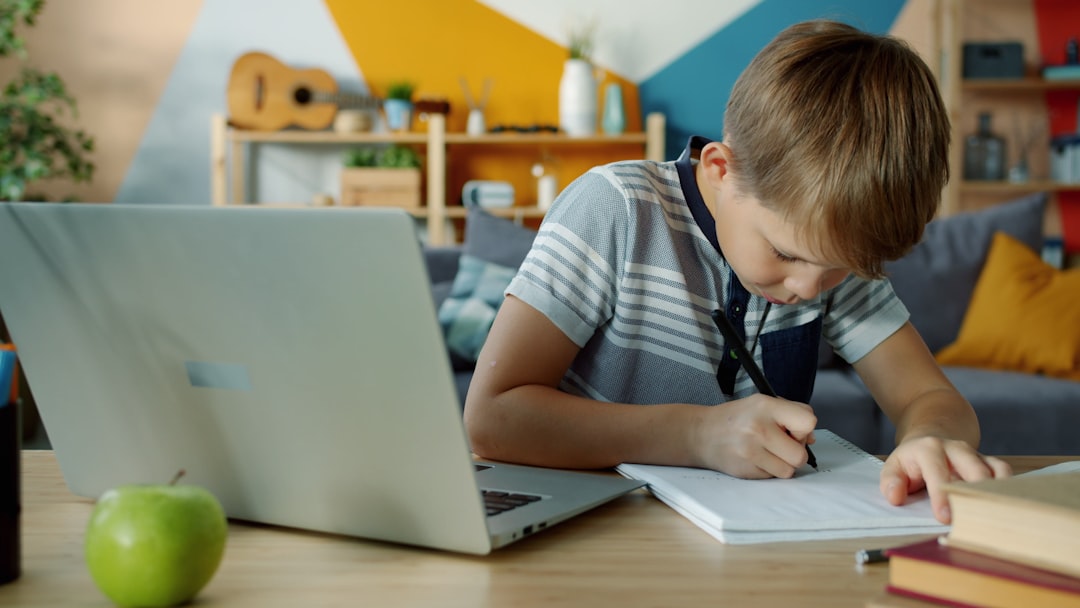 Ragazzo studia con laptop e quaderno per recuperare le materie insufficienti prima dell'esame di riparazione