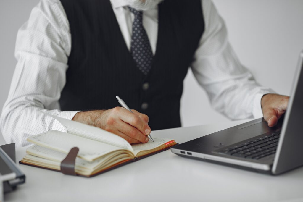 Professionista che prende appunti mentre lavora al computer